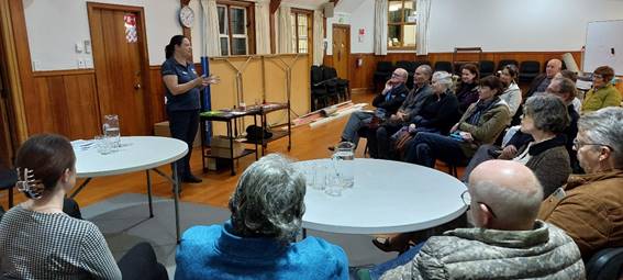 A person standing in front of a group of people sitting on a table

AI-generated content may be incorrect.