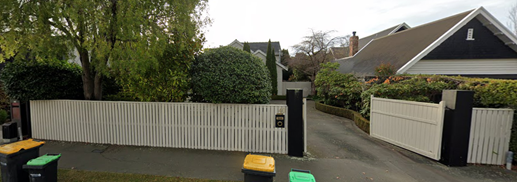 A white fence with a white picket fence and a bush

AI-generated content may be incorrect.