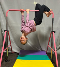 A child upside down on a pink bar

AI-generated content may be incorrect.