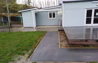 A house with a concrete driveway and grass

AI-generated content may be incorrect.