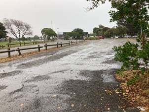 A wet road with trees and grass

AI-generated content may be incorrect.