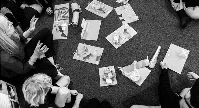 A group of people sitting on the floor

AI-generated content may be incorrect.