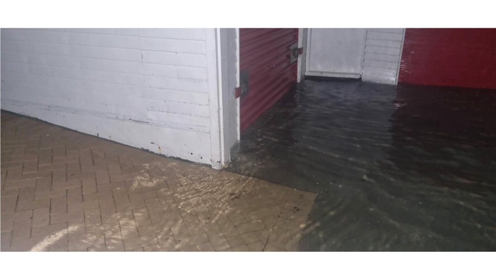 A flooded garage with a red door

AI-generated content may be incorrect.