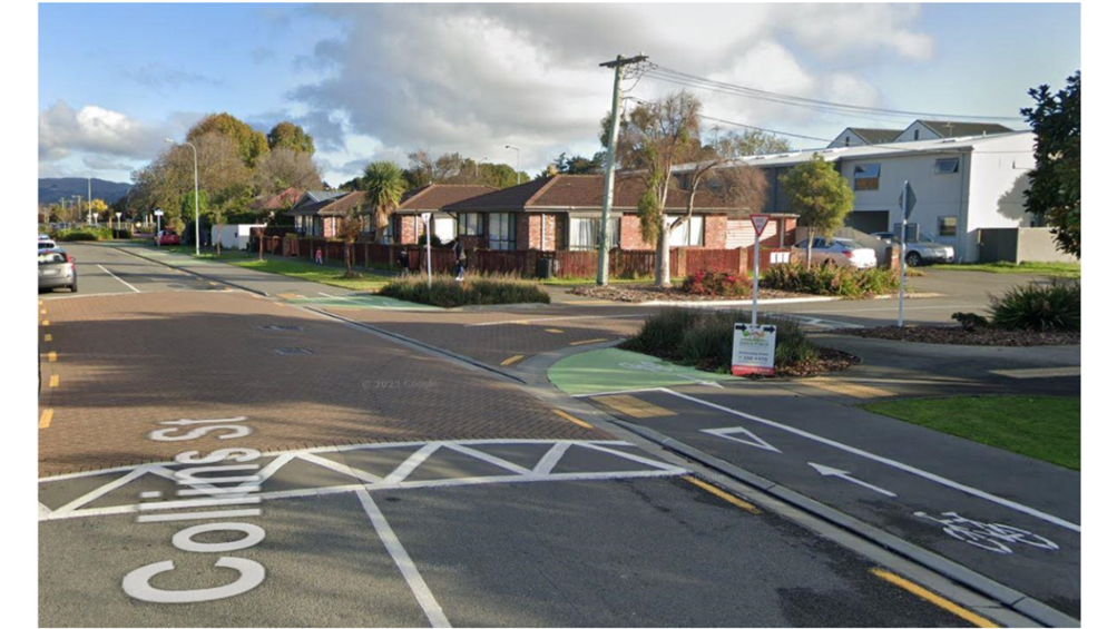 A street with houses in the background

AI-generated content may be incorrect.