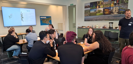 A group of people sitting around a table

AI-generated content may be incorrect.