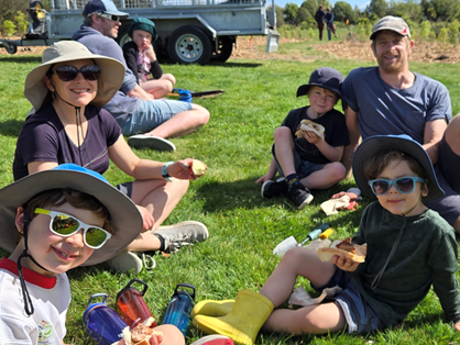 A group of people sitting on grass eating food

AI-generated content may be incorrect.