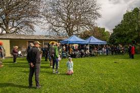A group of people standing in a grassy area

AI-generated content may be incorrect.
