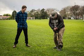 A person standing on grass with another person standing on grass

AI-generated content may be incorrect.