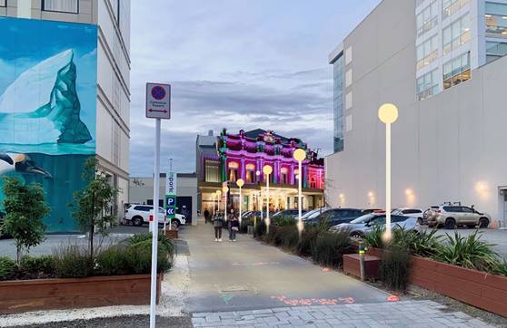 A street with buildings and cars

AI-generated content may be incorrect.